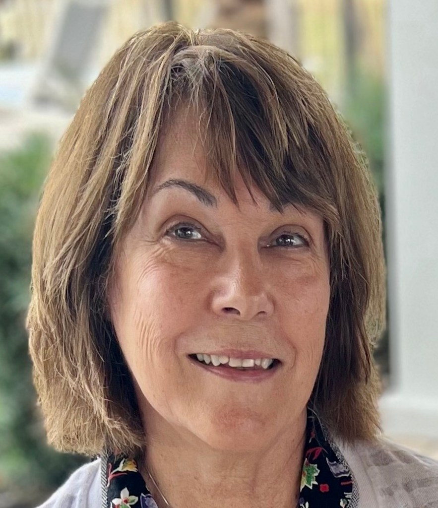 Sylvia Liszka Durrell is a white woman with brown bobbed hair and bangs. 