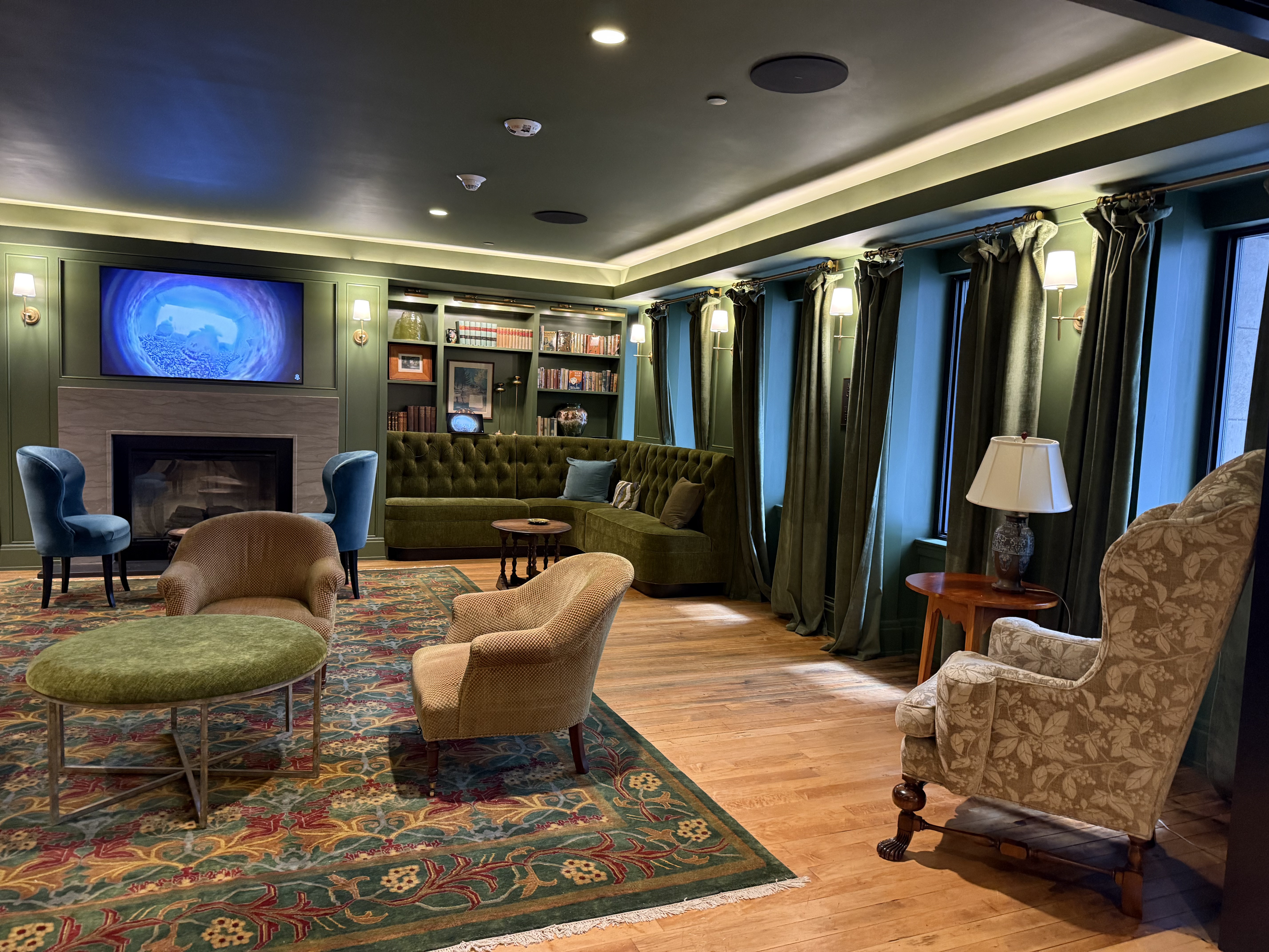 A stately room with carpets and green curtains